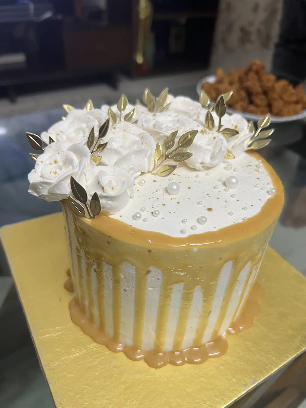 Tarta blanca con flores de azúcar y detalles dorados