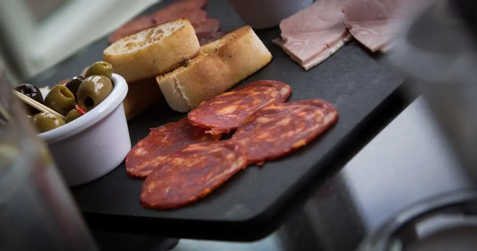 Tabla de embutido curado, pan y aceitunas