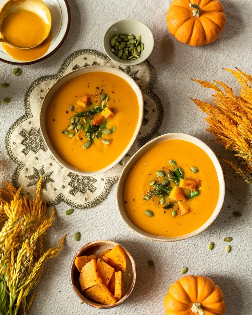 Cuencos de crema de calabaza sobre la mesa, vistos desde arriba