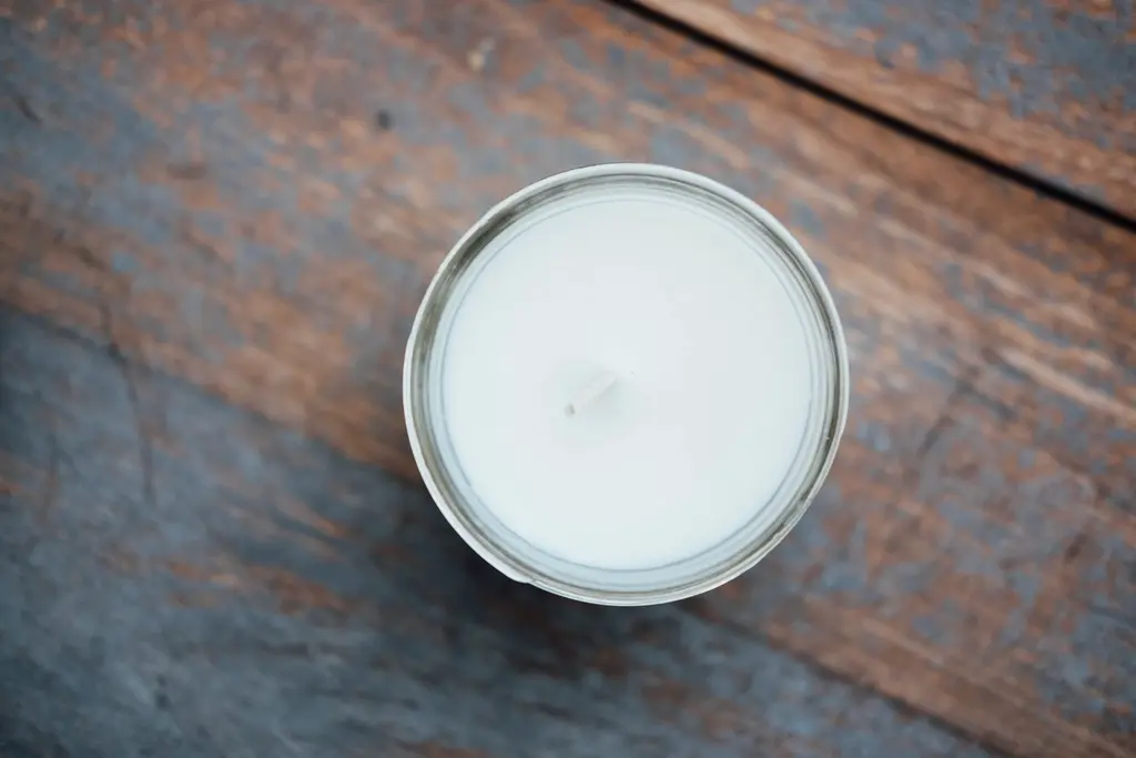 Vela blanca sobre una mesa de madera