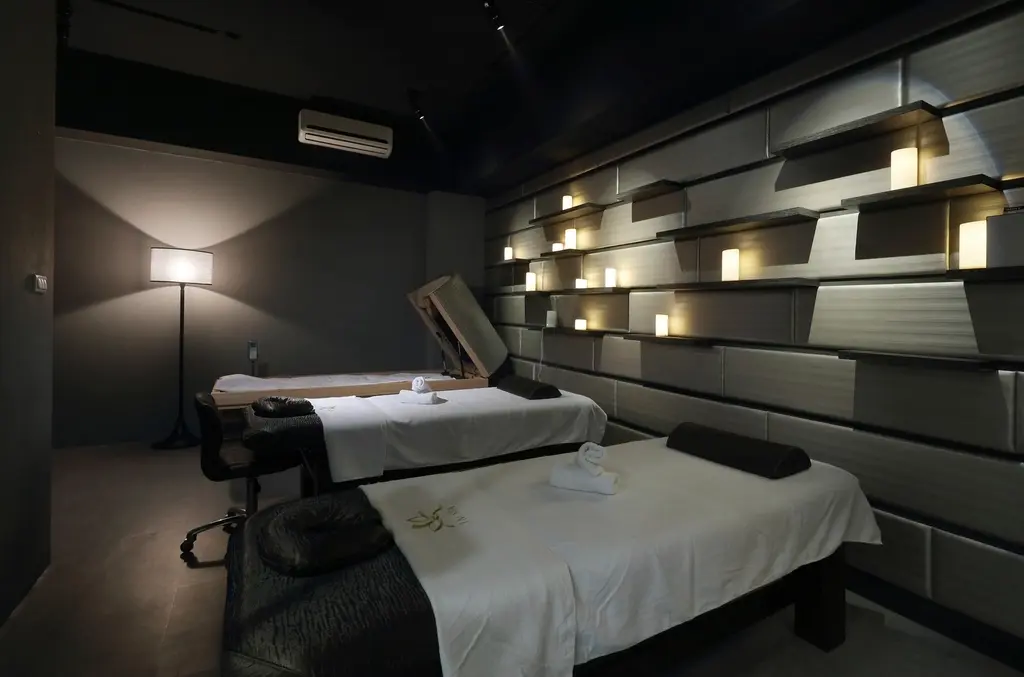 Cabina con dos camillas y la luz suave de una lámpara de pie