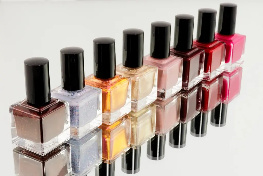 Frascos de esmalte de uñas en fila, de tonos nude a rojo