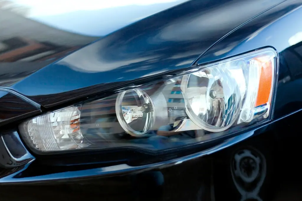 Faro delantero de un coche azul oscuro, limpio y brillante