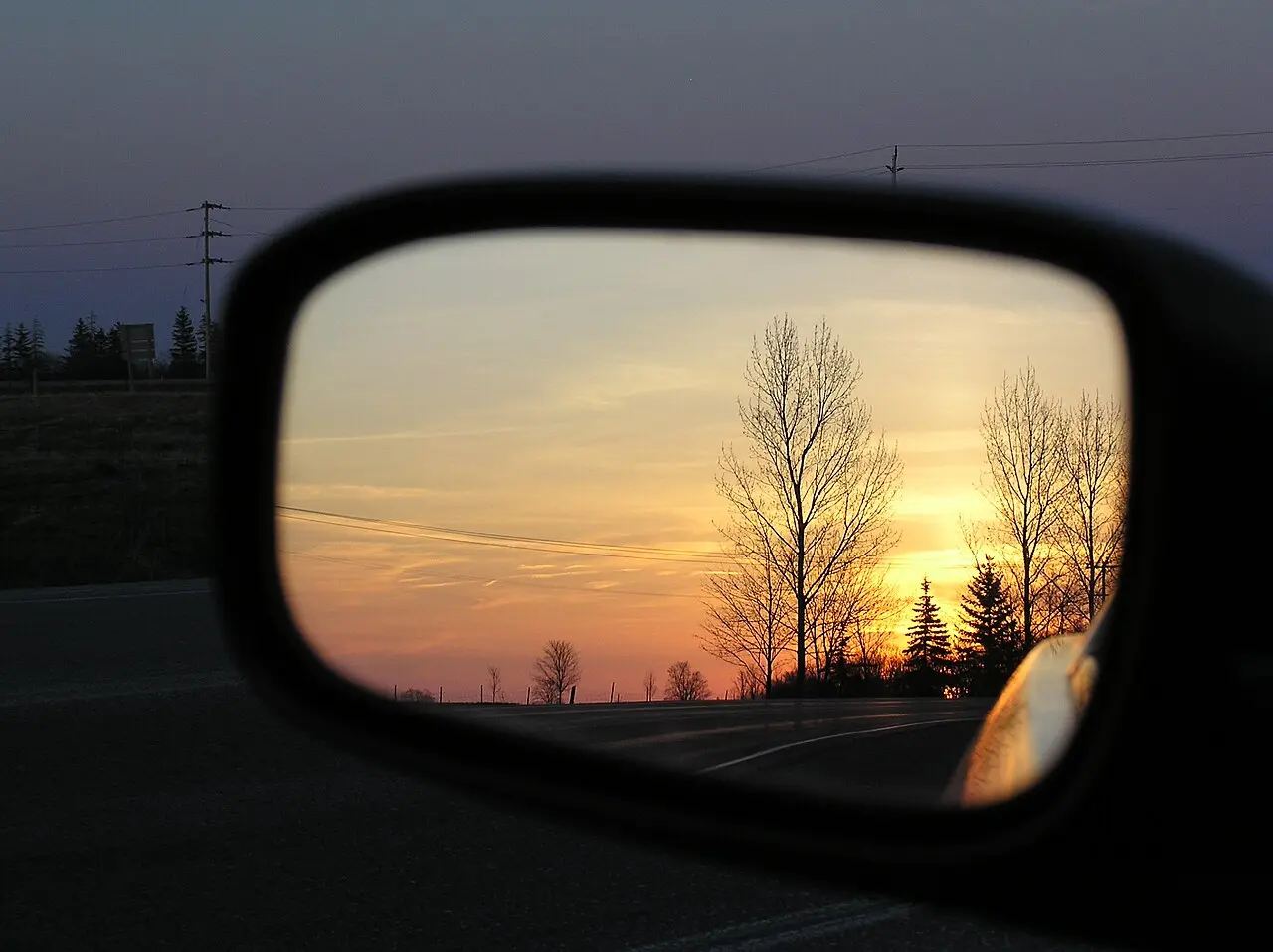 Retrovisor de coche entero reflejando una puesta de sol