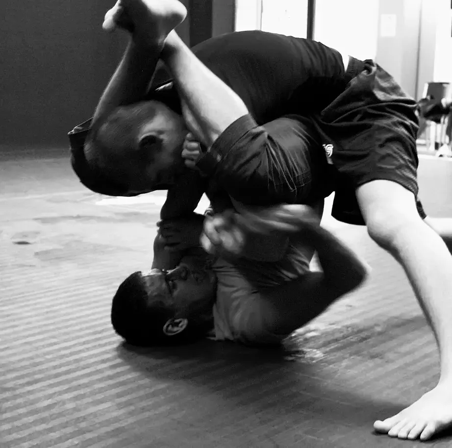 Dos personas luchando en el tatami, una intenta pasar la guardia de la otra