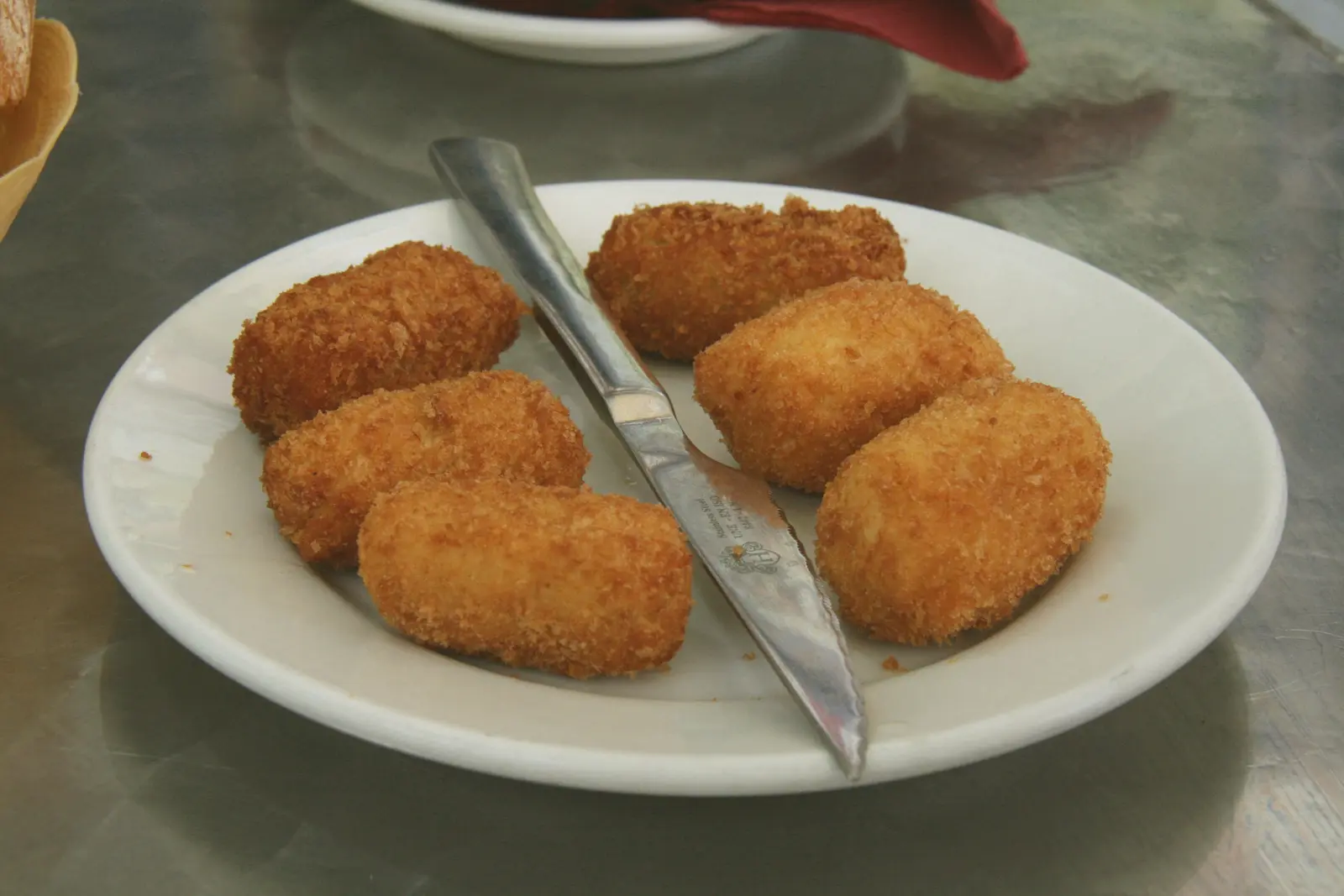 Croquetas caseras en un plato blanco, recién fritas