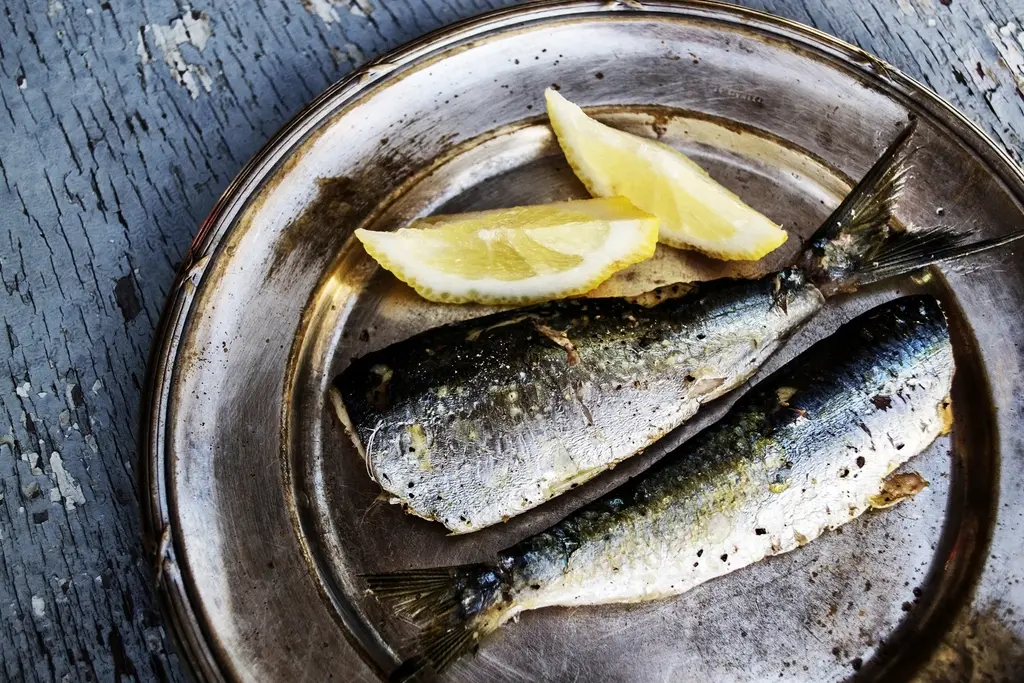 Sardinas a la brasa con limón en una fuente de metal
