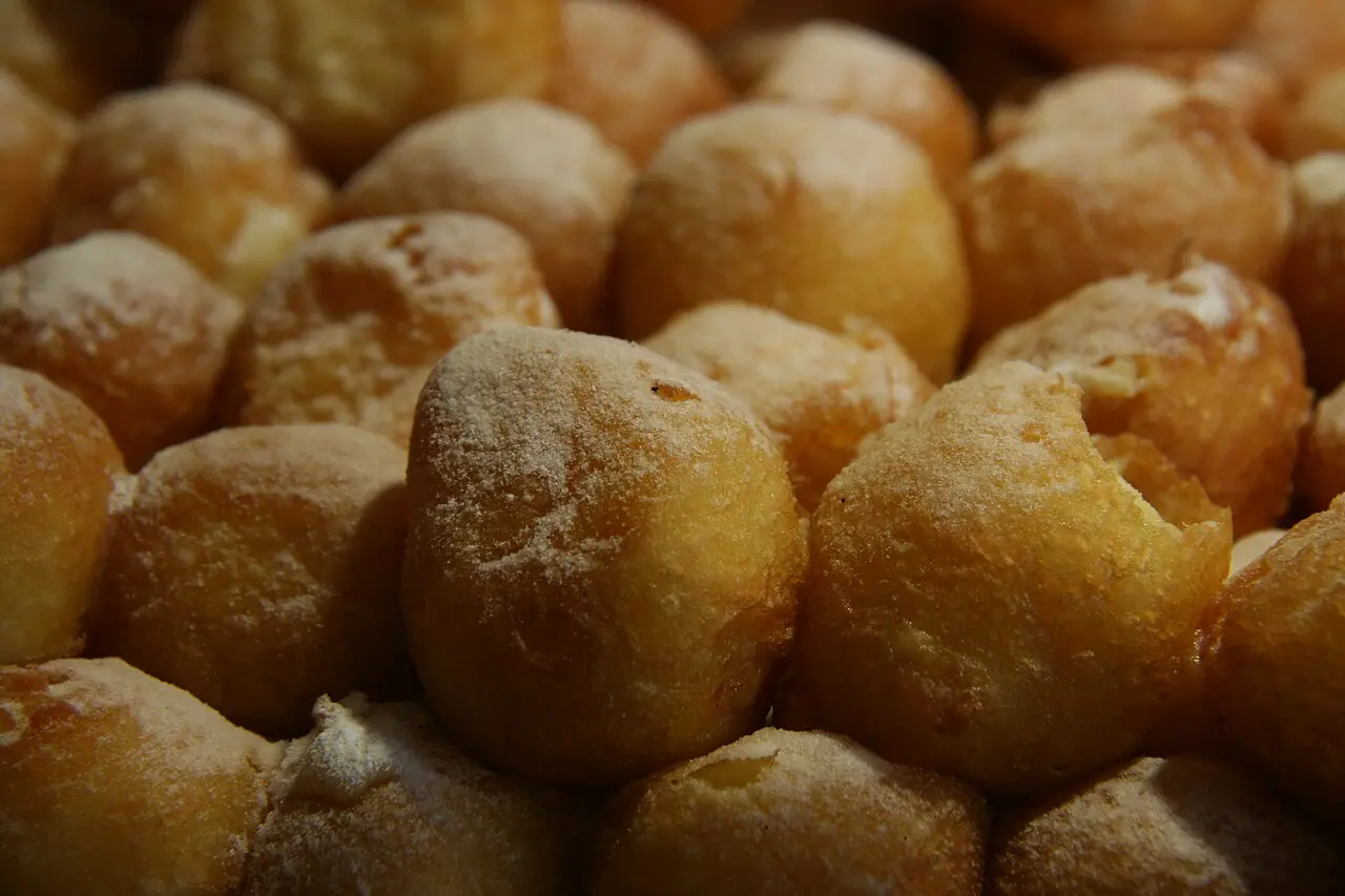 Buñuelos de viento dorados y espolvoreados de azúcar, recién hechos