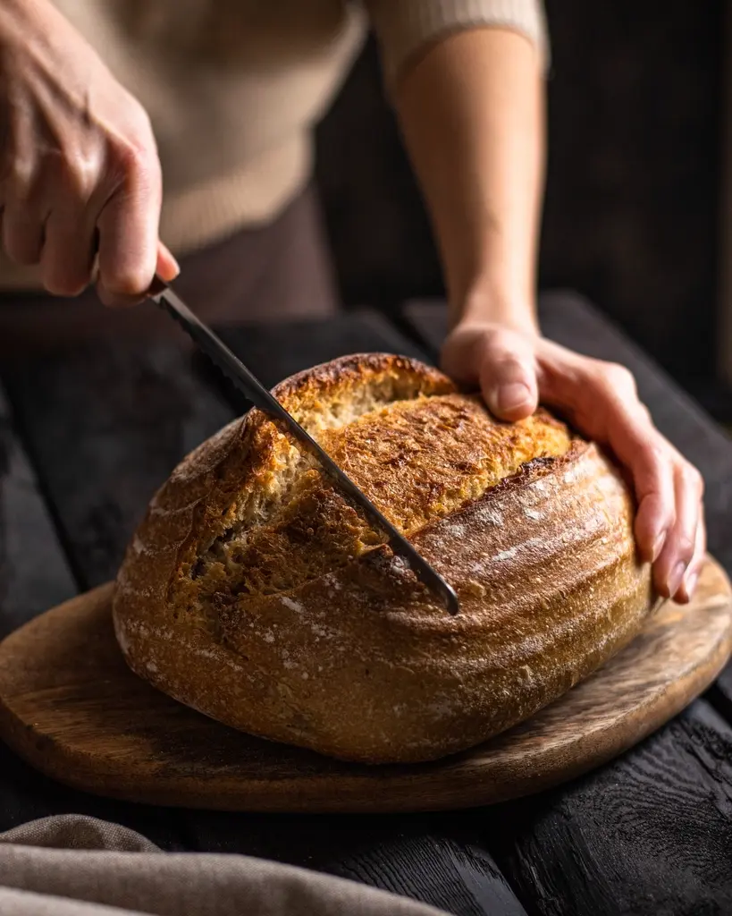 Hogaza de masa madre cortada sobre una tabla de madera