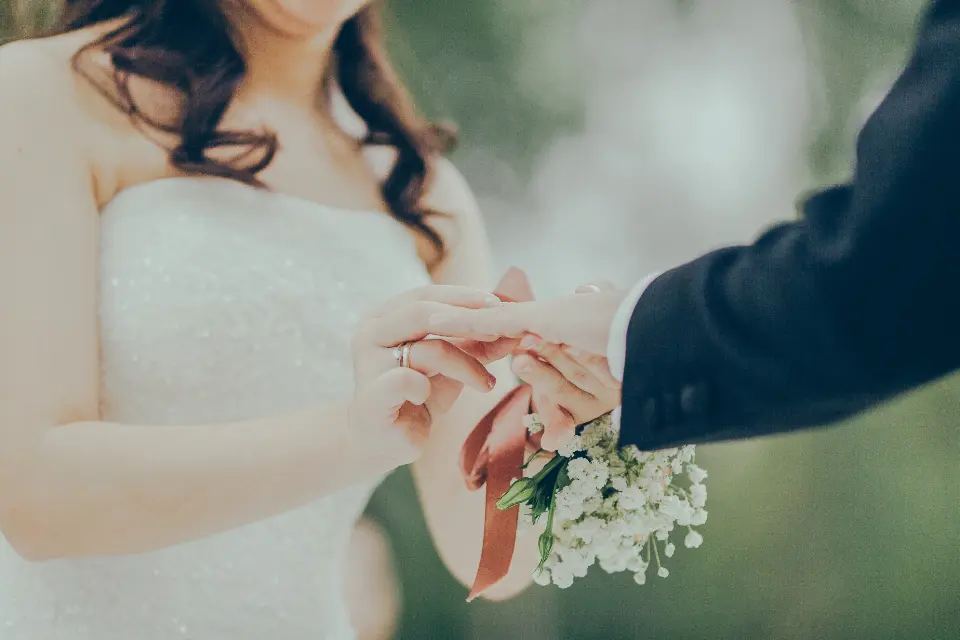 Las manos de los novios con las alianzas recién puestas