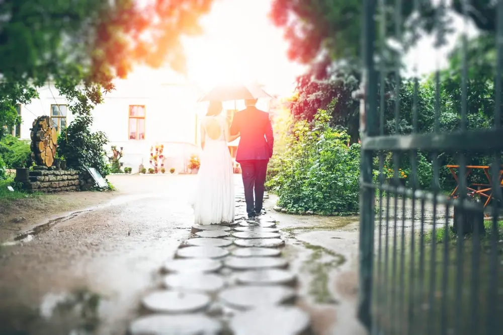 La pareja cruza un jardín por un camino de losas redondas