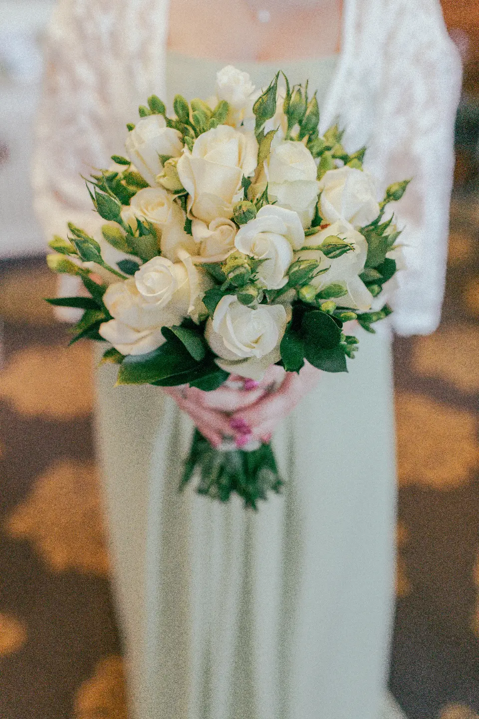 Ramo de rosas blancas sobre el vestido