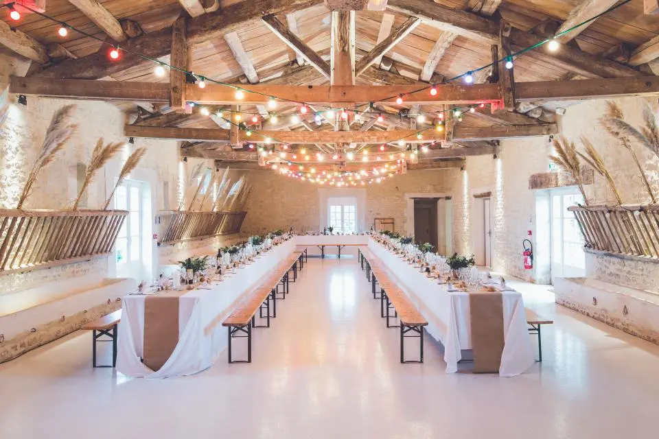 Salón con mesas largas y guirnaldas de luces