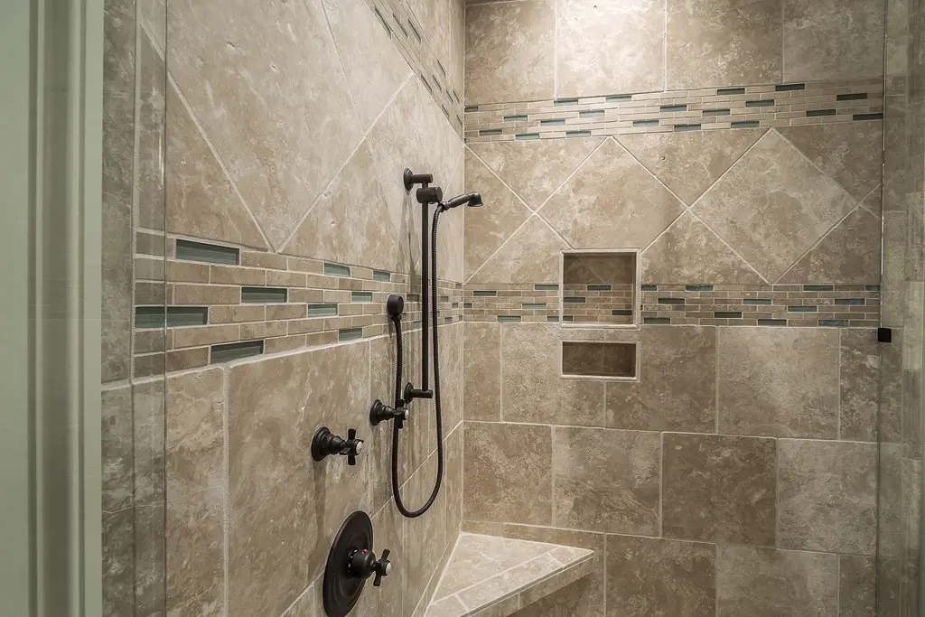 Ducha de obra con baldosa de piedra beis, cenefa de mosaico y hornacina