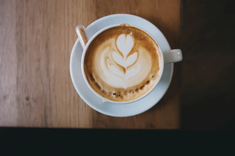 Flat white con dibujo de hoja, visto desde arriba