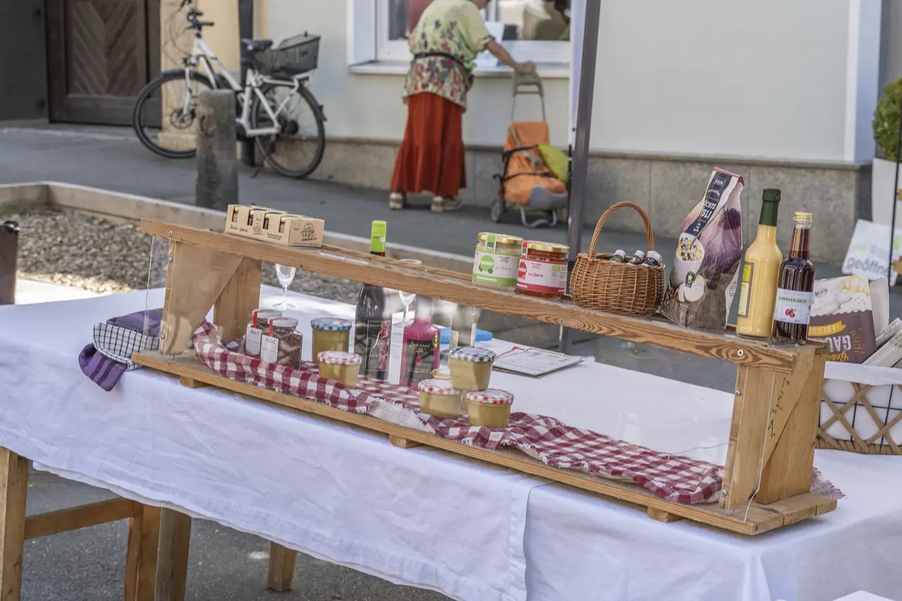 Puesto de mercado al aire libre con tarros y botes sobre una mesa de madera