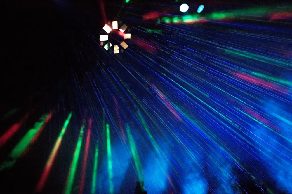 Rayos de luz de colores sobre la gente en la oscuridad