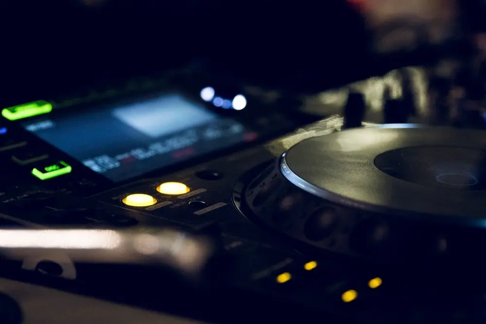 Reproductor de DJ con luces amarillas en la penumbra