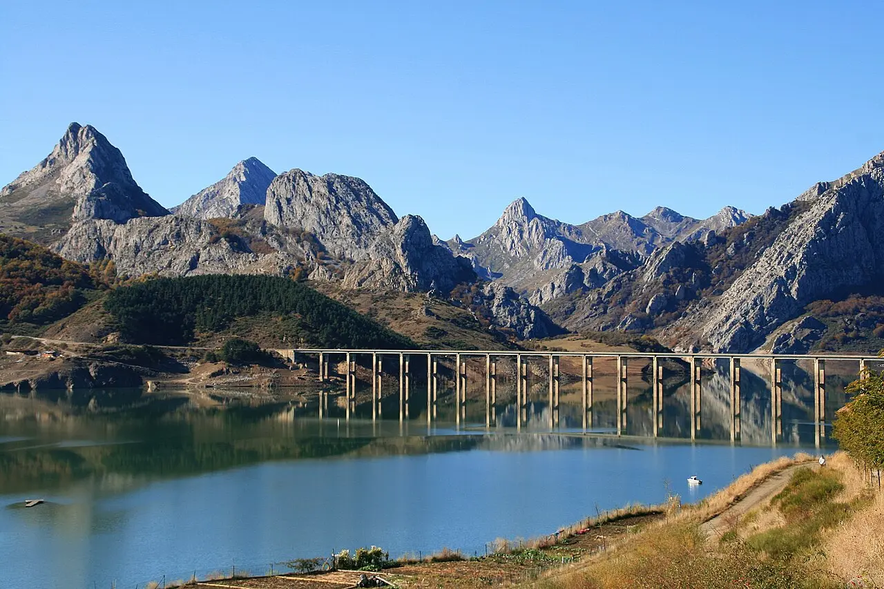 El embalse de Riaño con el viaducto de la carretera y las peñas calizas al fondo, en un día despejado.