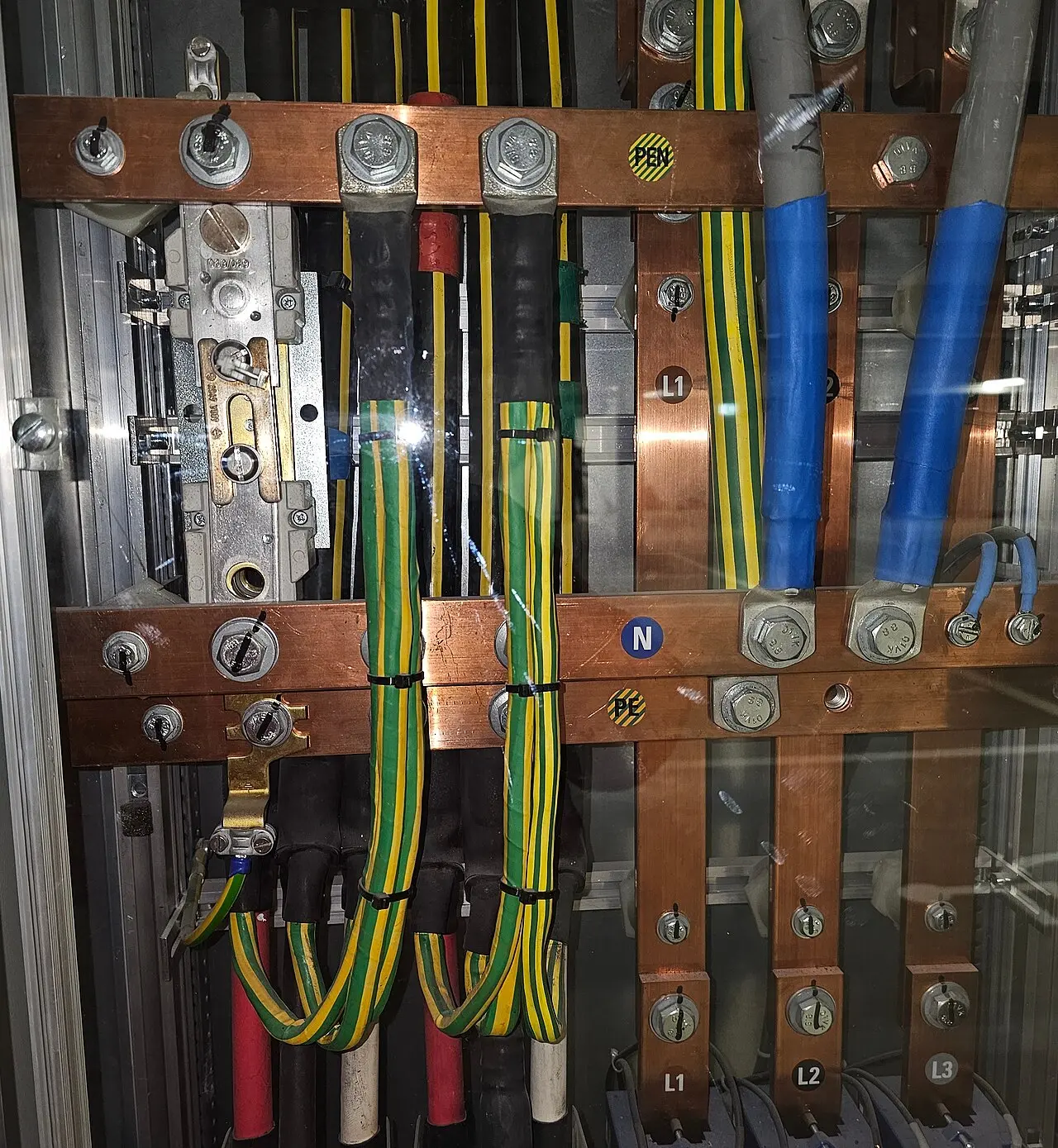 Embarrado de cobre y cables de tierra en un cuadro de fuerza abierto