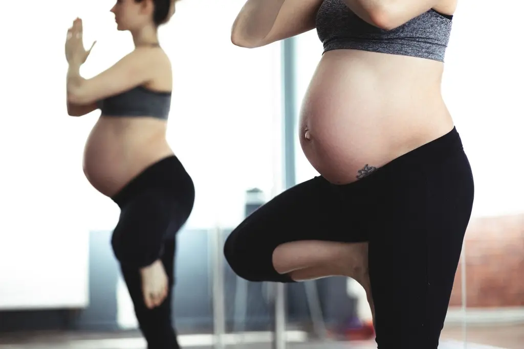 Dos mujeres embarazadas haciendo un ejercicio de equilibrio de pie, sin verse sus caras