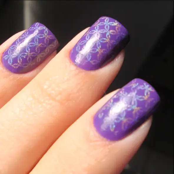 Uñas lilas con un estampado de encaje plateado